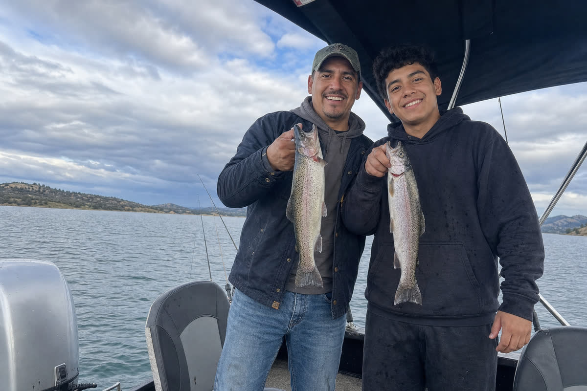Dave and his son holding rainbow trout on the boat
